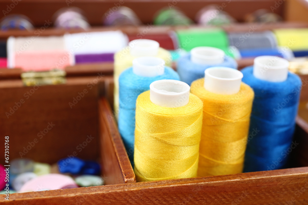 Colorful threads for needlework in wooden box close up