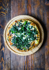 Wall Mural - Spinach and goat cheese pizza on wooden background