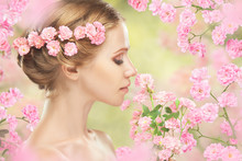 Young Beautiful Woman With Pink Flowers In Her Hair