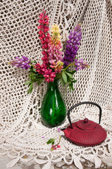 Wall Mural - still life bouquet with lupinus in a green vase and tea pot