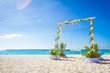 wedding swing decorated with flowers on tropical sand beach, out