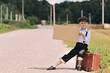 boy hitch hiking on the road
