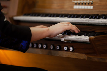 Wall Mural - Hands of a woman playing the organ