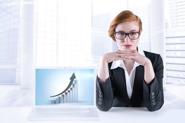 Poster - Composite image of redhead businesswoman sitting at desk