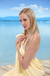 Dziewczyna, blondynka w ręczniku kąpielowym nad jeziorem.