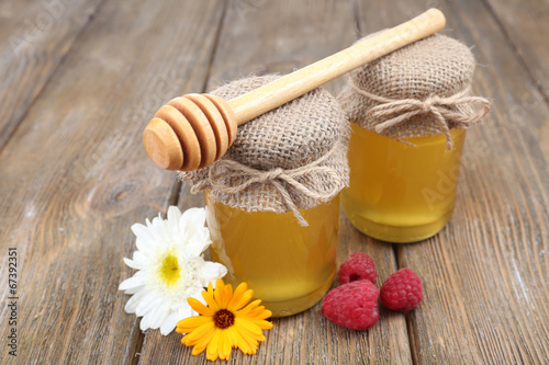 Fototapeta na wymiar Jar full of delicious fresh honey and wild flowers