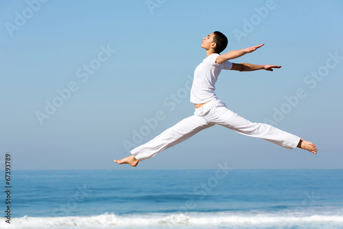 Fototapeta na wymiar young woman dancing on beach