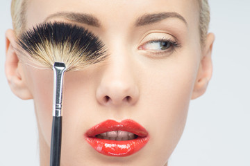 Wall Mural - Beautiful Young Woman Applying Makeup with Brush