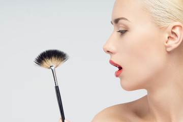 Wall Mural - Beautiful Young Woman Applying Makeup with Brush