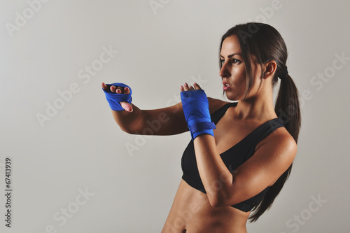 Leinwand Poster fitness woman with the blue boxing bandages, studio shot