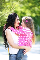 Wall Mural - Happy mom and daughter. Walk in the green park