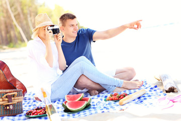 Poster - Young couple taking pictures at the beach