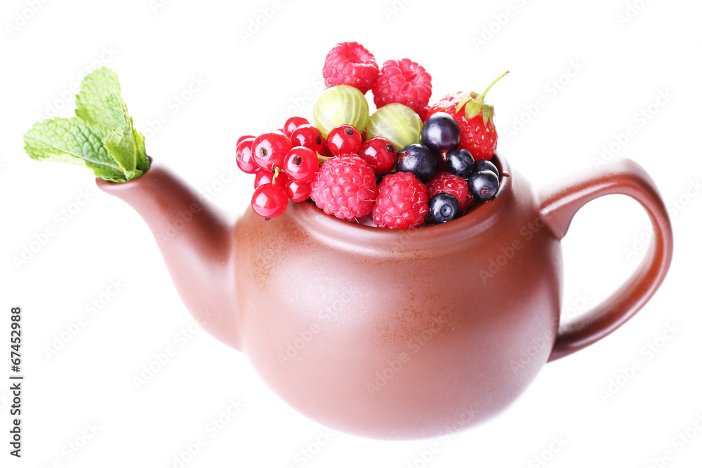 Forest berries and mint leaves in teapot, isolated on white