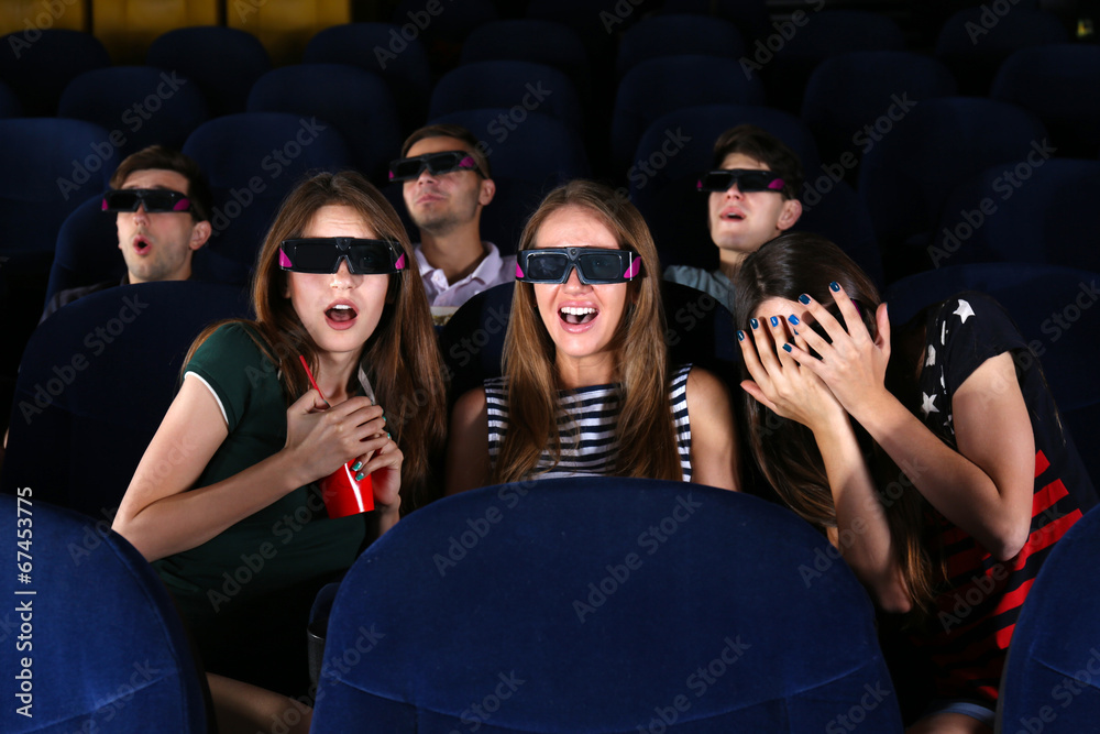 Young people watching movie in cinema
