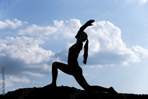 Poster Pretty woman doing yoga exercises in the park. silhouette.