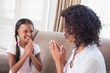 © WavebreakmediaMicro - Pretty mother playing clapping game with daughter on couch