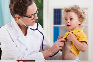 Wall Mural - Female doctor examining little sweet boy