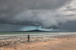 woman walking on Takapuna beach at storm
