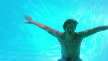 Happy Man Posing Underwater In Swimming Pool