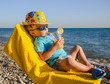 © Svetlaya - Boy kid in armchair with juice glass on beach