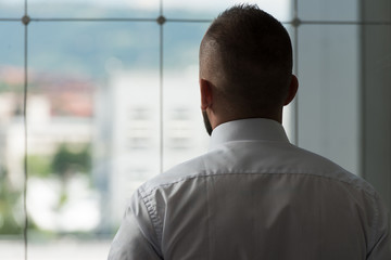 Rear View Of A Business Man Standing In Boardroom