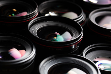 Modern camera lenses with reflections, low key image