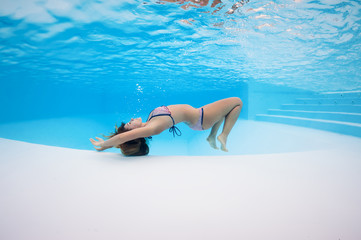 Underwater woman portrait in swimming pool.