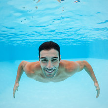 Smiling Underwater Man Portrait Inside Swimming Pool.