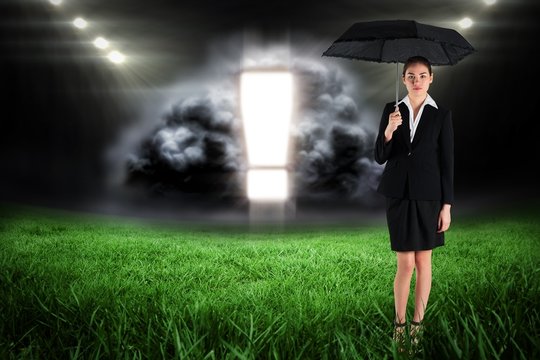 Composite image of young businesswoman holding umbrella