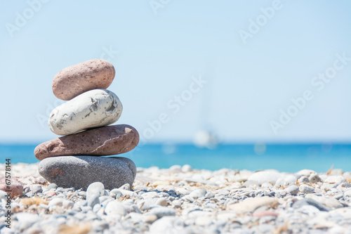 Naklejka na szybę Stos kamieni ułożony na plaży przy wodzie