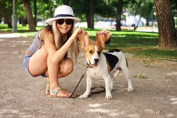 happy young woman playing with Beagle dog outdoors . funny shot