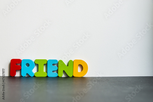 Fotografia, Obraz Colorful wooden word Friend with white background
