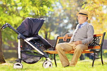 Wall Mural - Grandfather sitting and looking at his baby nephew in a stroller