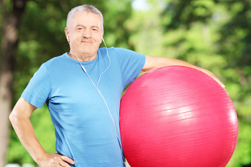 Sticker - Mature sporty man holding a fitness ball in park