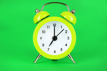 Wall Mural - Light green alarm clock on green background