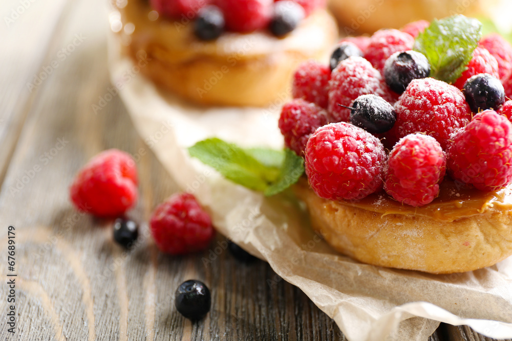 Sweet cakes with berries on table close-up