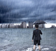 business man holding an umbrella and standing  with cloudburst