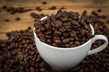 Coffee cup and coffee beans on a wooden table