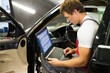 © Nejron Photo - Serviceman making car diagnostics with laptop in a workshop