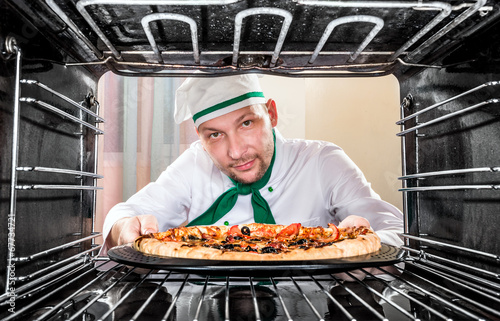 Obraz w ramie Chef cooking pizza in the oven.