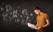 © ra2 studio - Young man reading a book with alphabet letters