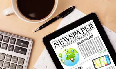 Wall Mural - tablet pc shows news on screen with a cup of coffee on a desk