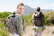 © WavebreakMediaMicro - Attractive hiking couple walking on mountain trail woman smiling