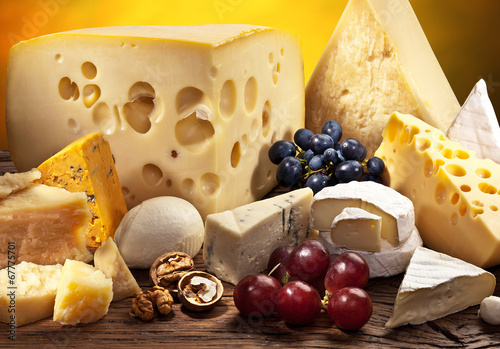 Fotografie, Obraz Different types of cheese over old wooden table.