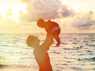 Wall Mural - Father and little daughter playing on sunset beach