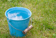 Blue bucket of water on grass