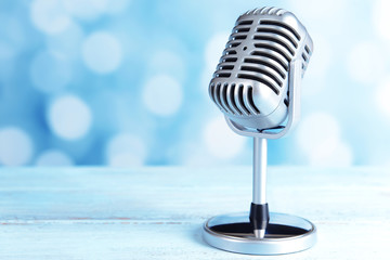 Wall Mural - Vintage microphone on table on light blue background