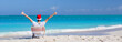 © travnikovstudio - Back view of young man in Christmas hat at beach chair