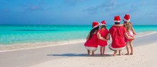 Two Parents And Kids In Santa Hat On White Beach