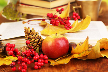 Fototapete - Books and autumn leaves on wooden table close-up